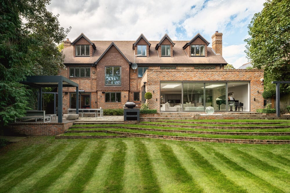 The garden view of an extensive, 3-floor property in Beaconsfield, Buckingshire, featuring Schueco windows and doors