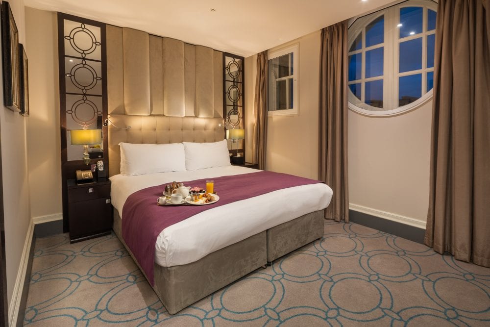 Breakfast tray on a bed in a 5-star London Hotel. London Hotel photography.