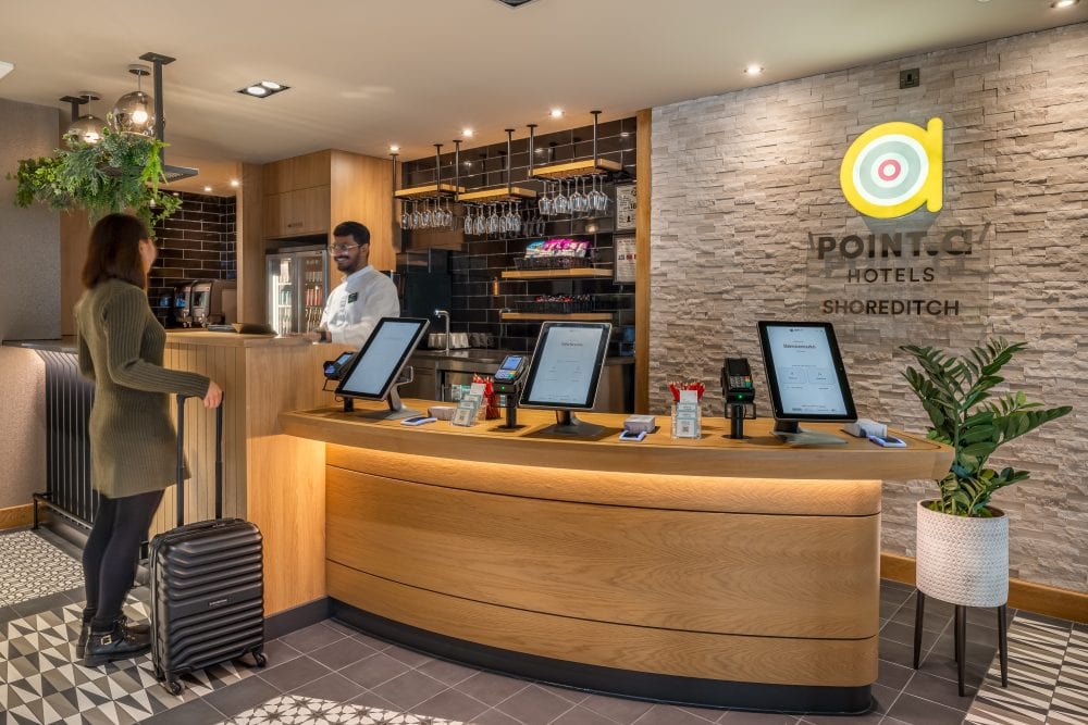 Guest arrives at modern hotel reception. London hotel photography