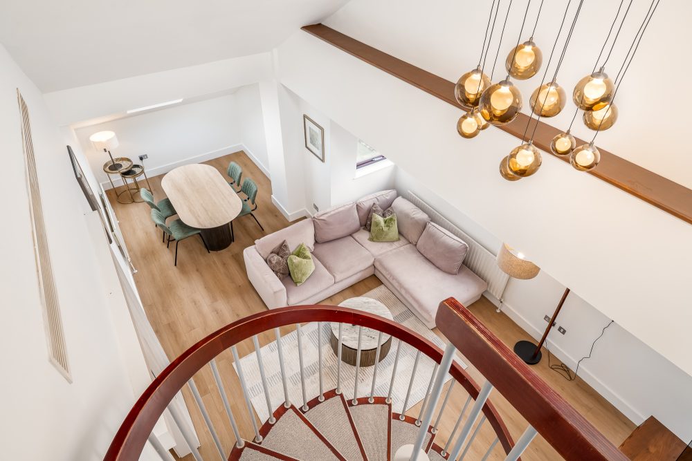 Looking down from mezzanine level into living room of luxury serviced apartment in London