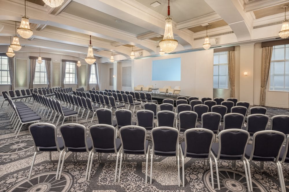 Large conference room with seating around a stage set up for a discussion